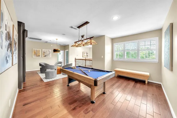 a living room with furniture a table and wooden floor