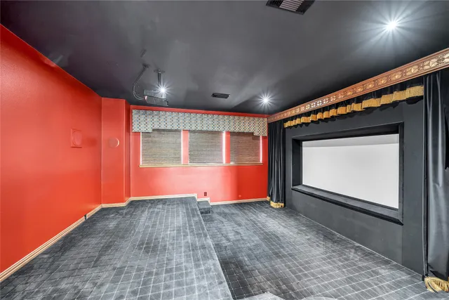 an empty room with chandelier fan and windows