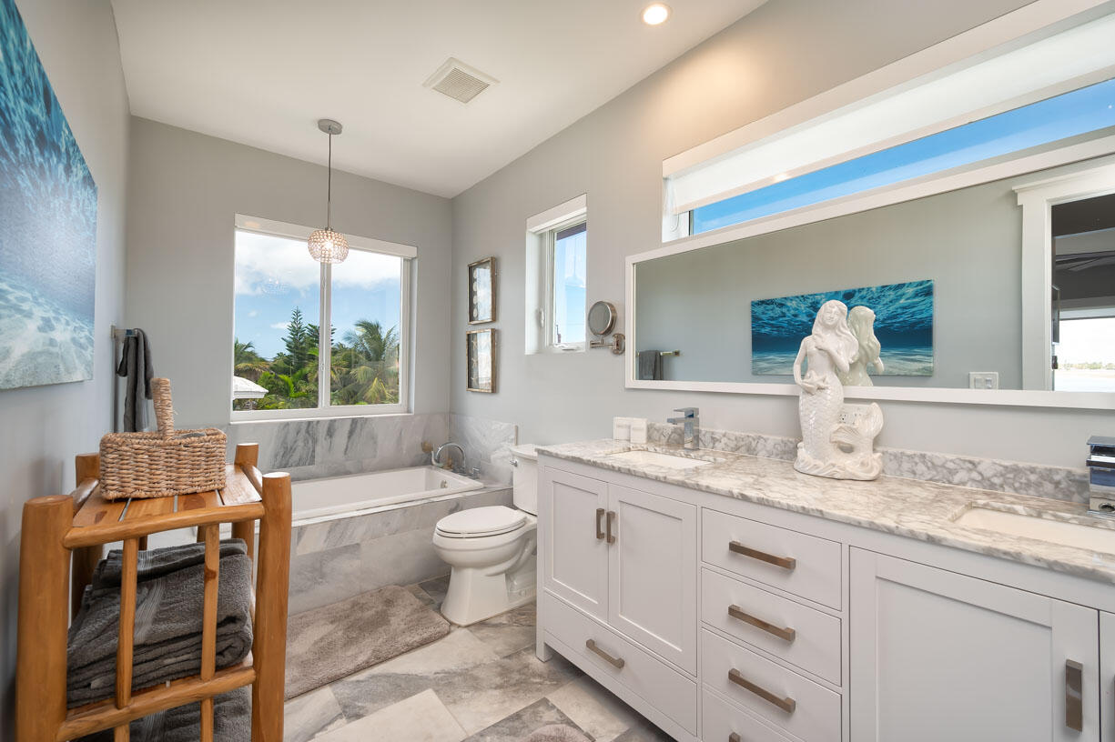 14 East Ocean Drive Marathon, FL 33050 - Photo 14 of 48 a bathroom with a granite countertop sink mirror vanity and toilet