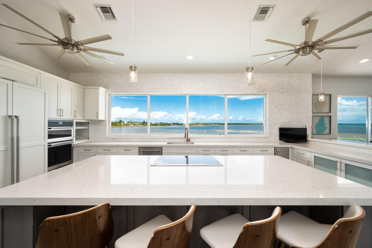 14 East Ocean Drive Marathon, FL 33050 - Photo 2 of 48 a kitchen with a dining table chairs stainless steel appliances and cabinets
