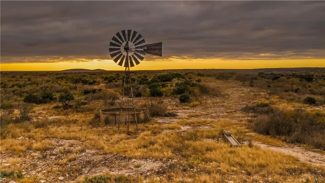 a room with stainless steel appliances table chairs and a wine table