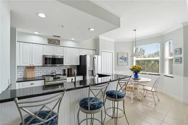 a kitchen with granite countertop a table and chairs in it