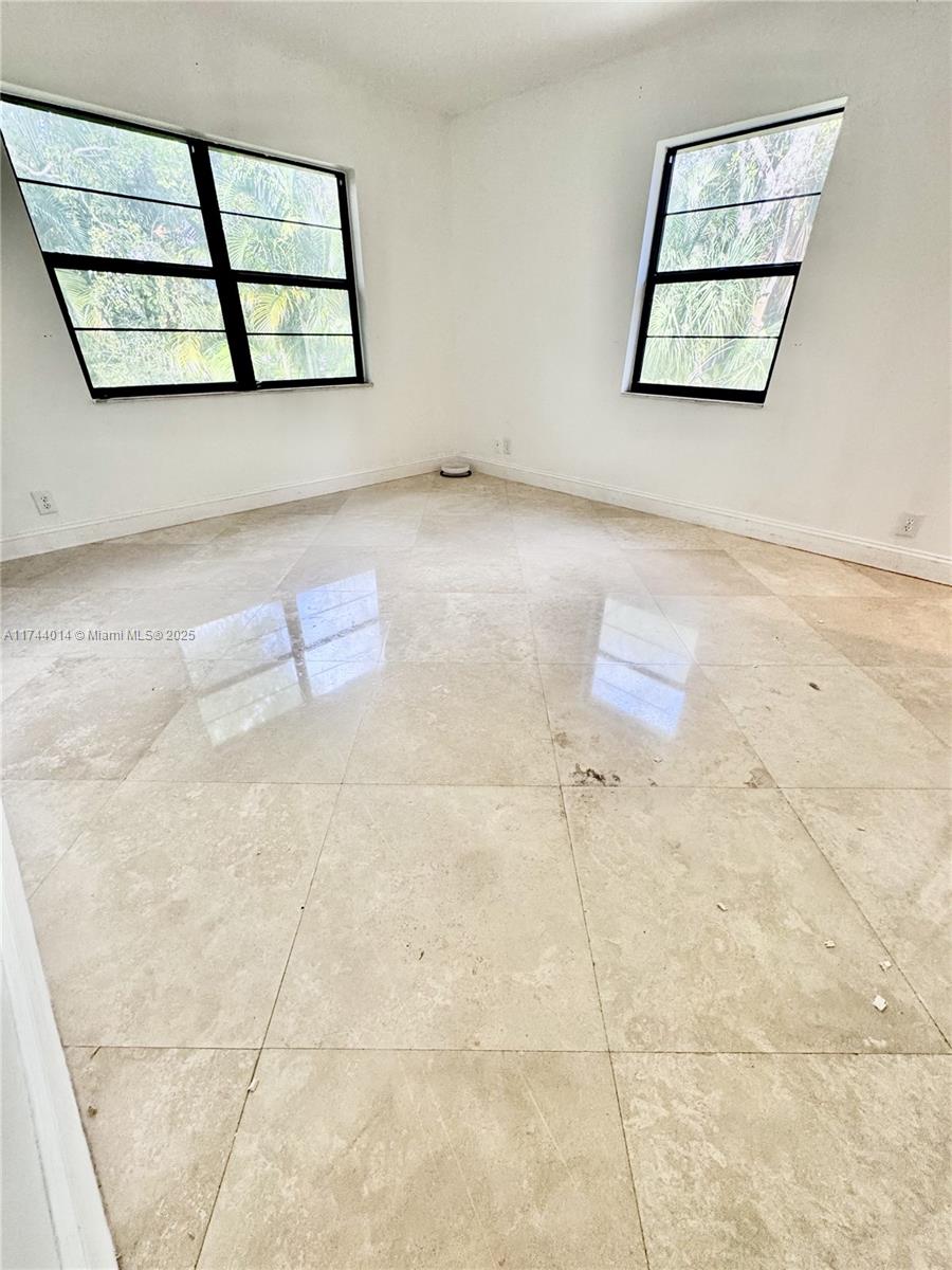140 South Cypress Road, Unit 128 Pompano Beach, FL 33060 - Photo 12 of 13 an empty room with windows and a ceiling fan