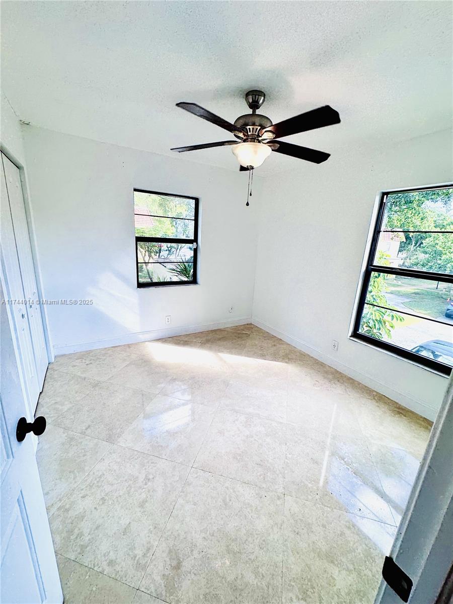 140 South Cypress Road, Unit 128 Pompano Beach, FL 33060 - Photo 2 of 13 an empty room with windows and fan