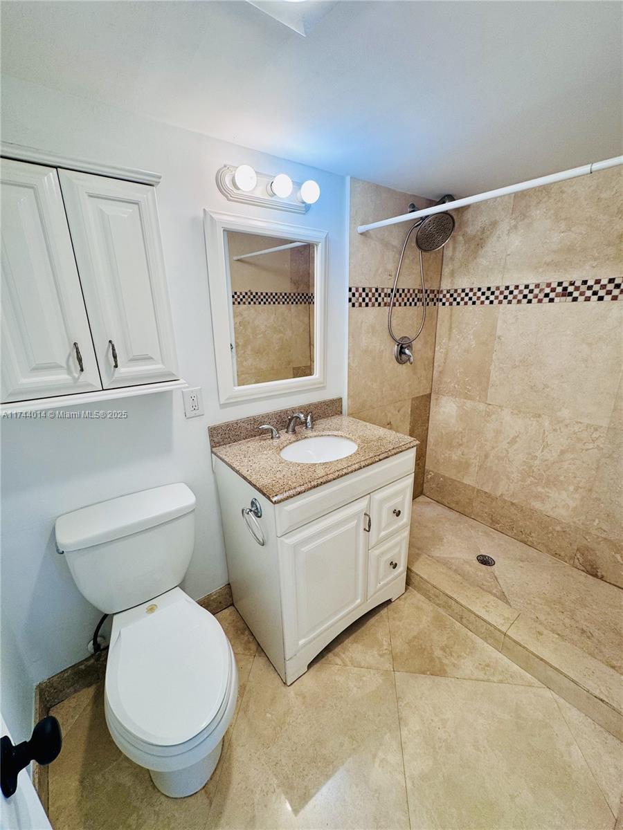 140 South Cypress Road, Unit 128 Pompano Beach, FL 33060 - Photo 6 of 13 a bathroom with a granite countertop toilet sink and mirror