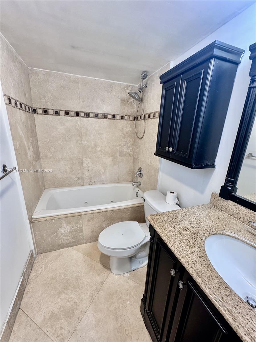 140 South Cypress Road, Unit 128 Pompano Beach, FL 33060 - Photo 7 of 13 a bathroom with a granite countertop sink toilet and shower