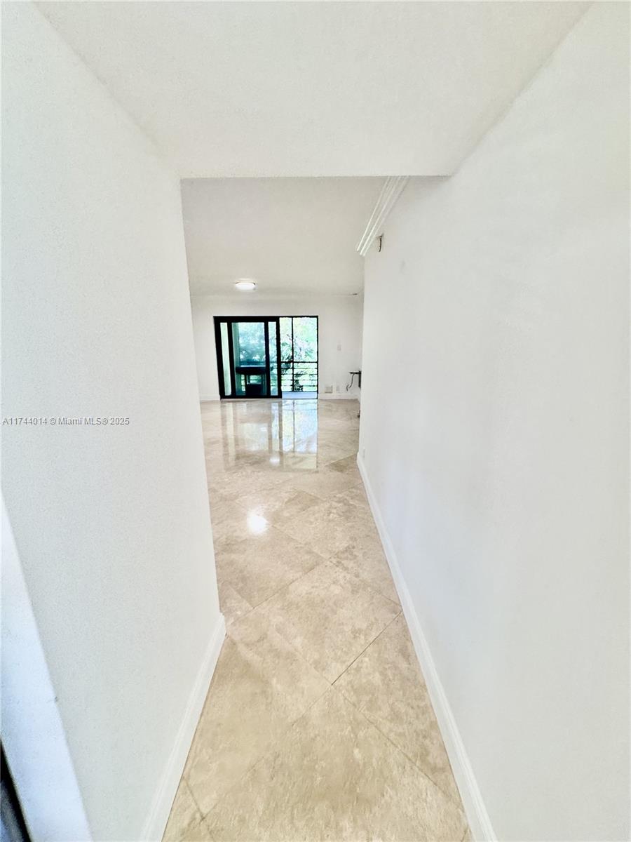 140 South Cypress Road, Unit 128 Pompano Beach, FL 33060 - Photo 10 of 13 a view of a hallway with wooden floor and a bathroom