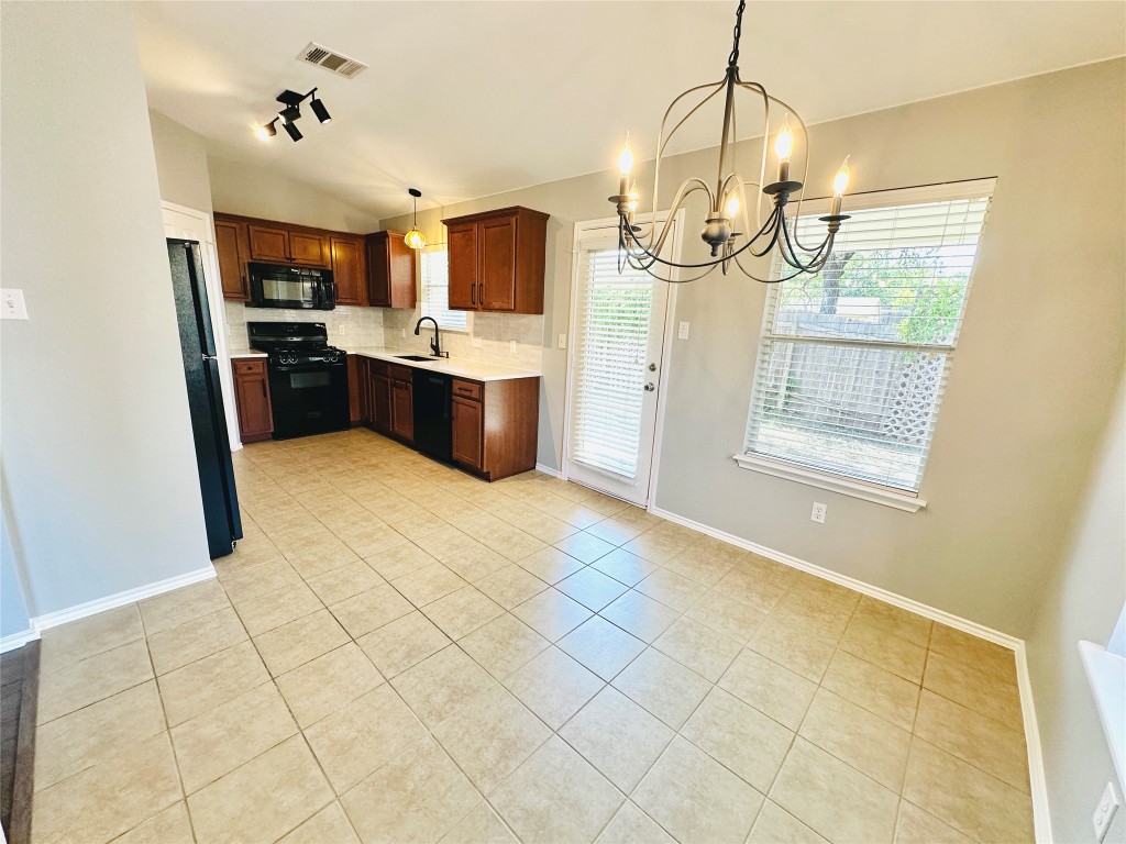 12112 Rancho Alto Road Austin, TX 78748 - Photo 18 of 34 a kitchen with stainless steel appliances kitchen island granite countertop a sink cabinets and window
