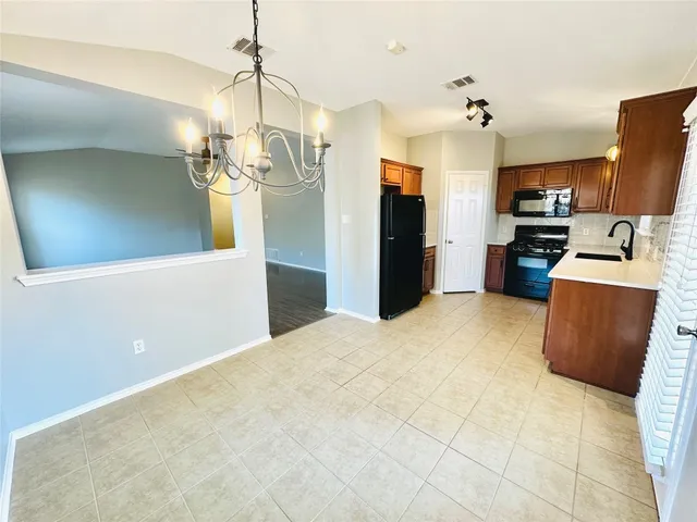 a kitchen with stainless steel appliances kitchen island granite countertop a refrigerator a stove top oven a sink and dishwasher