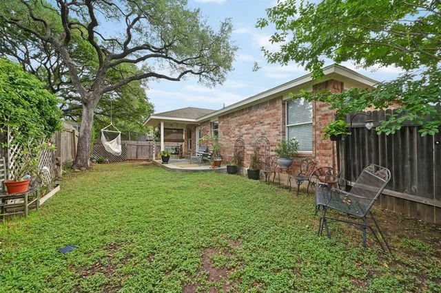 a view of a chair and table in backyard of the house