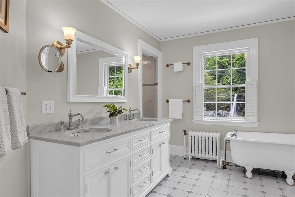 24 Sandy Pond Road Lincoln, MA 01773 - Photo 25 of 42 a bathroom with a double vanity sink bathtub and next to a window