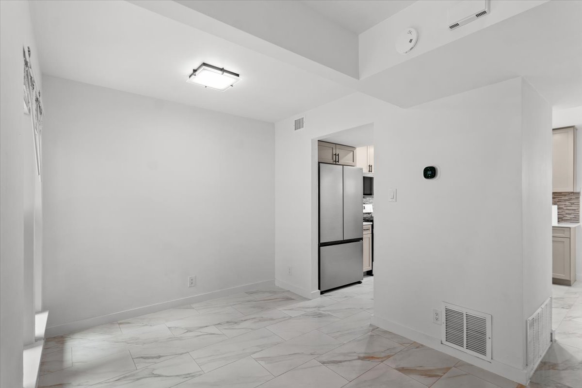 2500 Enfield Road, Unit 1 Austin, TX 78703 - Photo 8 of 26 Bright, open-concept dining space with sleek marble-patterned tile flooring flows seamlessly into the kitchen.
