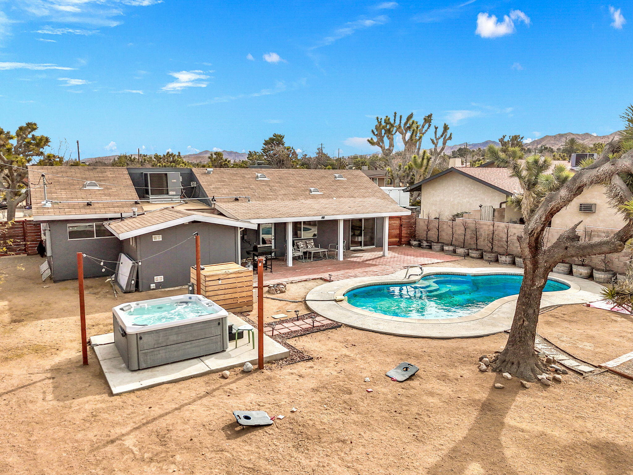 7552 Elk Trail Yucca Valley, CA 92284 - Photo 1 of 48 a front view of a house with a garden and outdoor seating