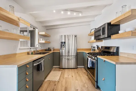a kitchen with stainless steel appliances granite countertop a sink stove and refrigerator