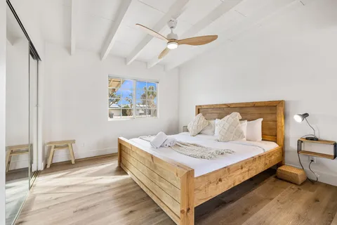 a bedroom with a bed and a painting on the wall