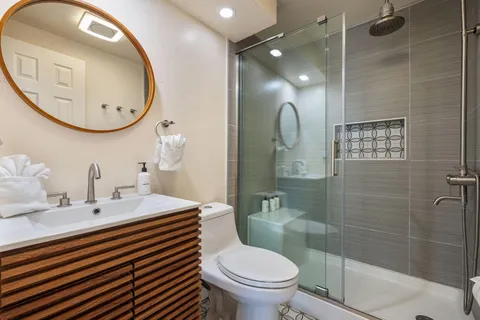 a bathroom with a sink a toilet and a mirror
