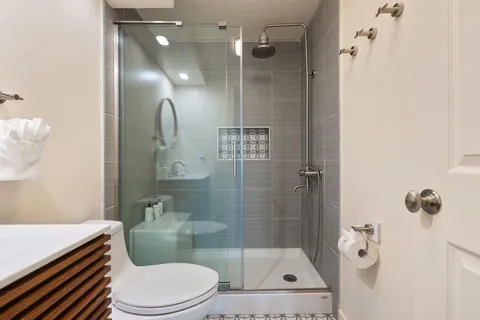 a bathroom with a sink a toilet and shower