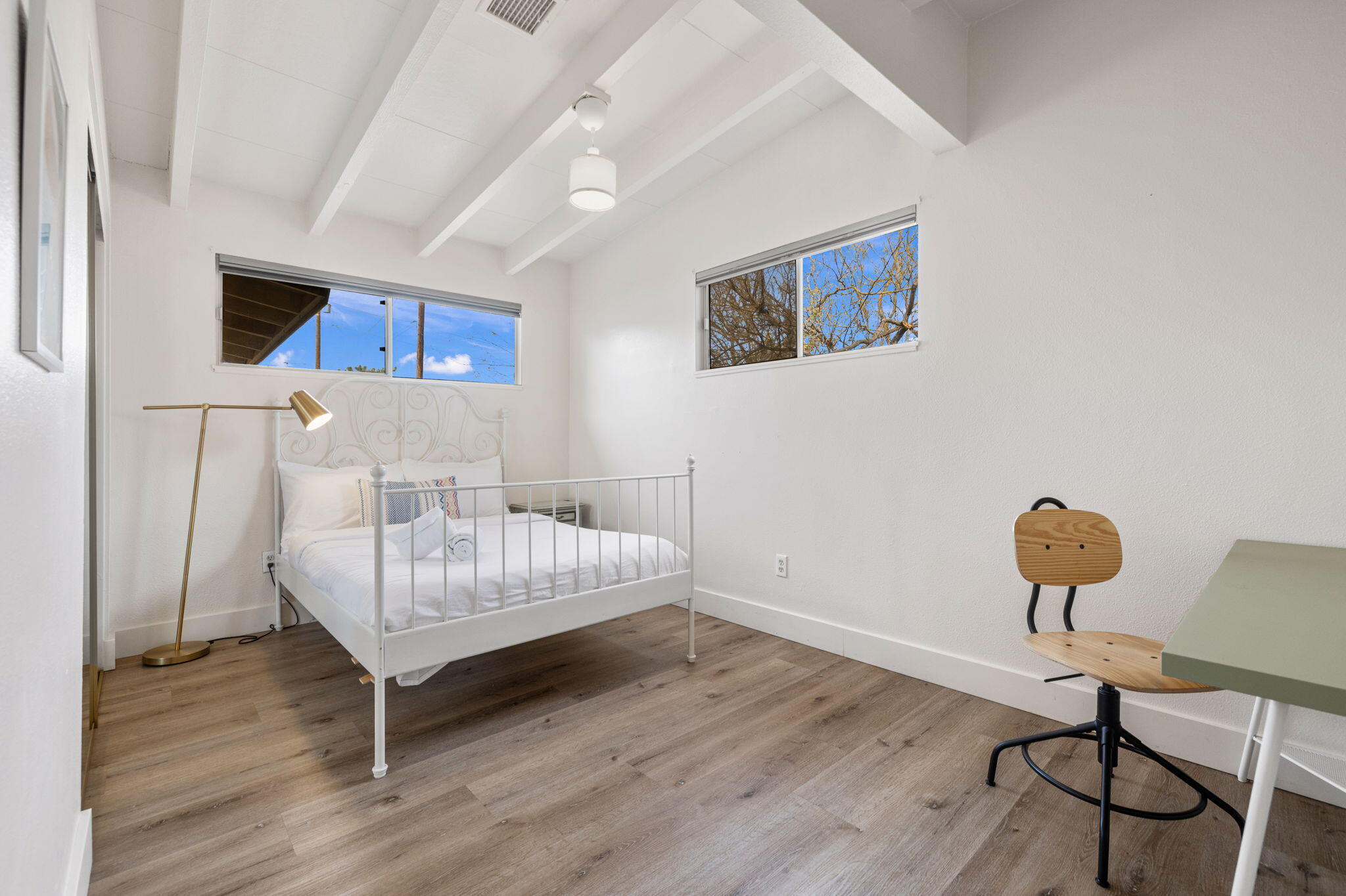 7552 Elk Trail Yucca Valley, CA 92284 - Photo 26 of 48 a bedroom with a bed and a chandelier