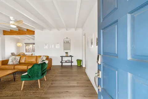 a living room with furniture and a wooden floor