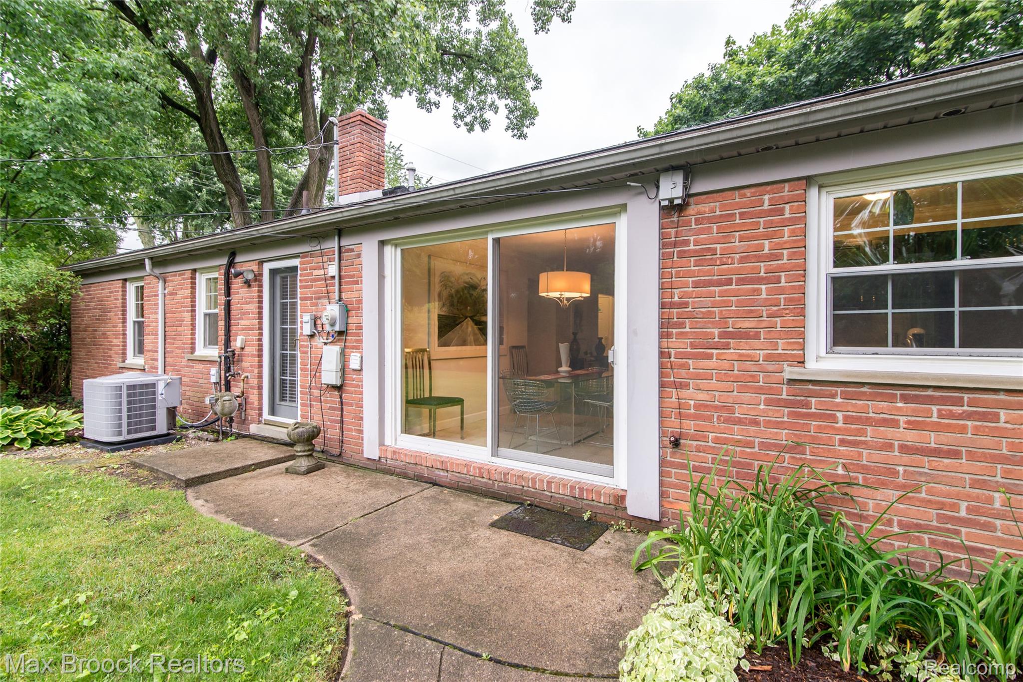 6799 East Dartmoor Road West Bloomfield, MI 48322 - Photo 25 of 36 Brick exterior featuring a sliding glass door, a brick chimney, and white-framed windows