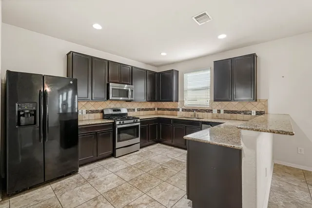 a kitchen with stainless steel appliances granite countertop stove sink and cabinets