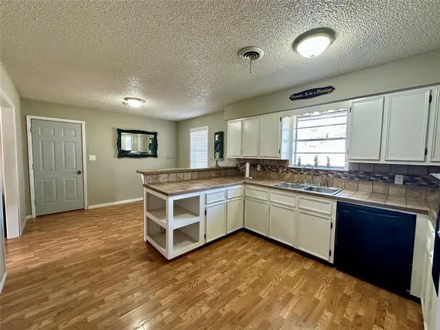 a kitchen with a stove sink and cabinets