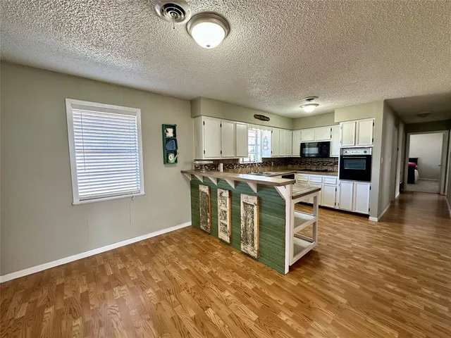 a kitchen with stainless steel appliances granite countertop a stove top oven a sink and a refrigerator