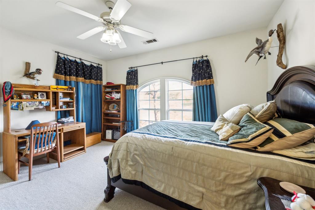 868 English Road Rockwall, TX 75032 - Photo 20 of 37 a bedroom with a bed and a chandelier