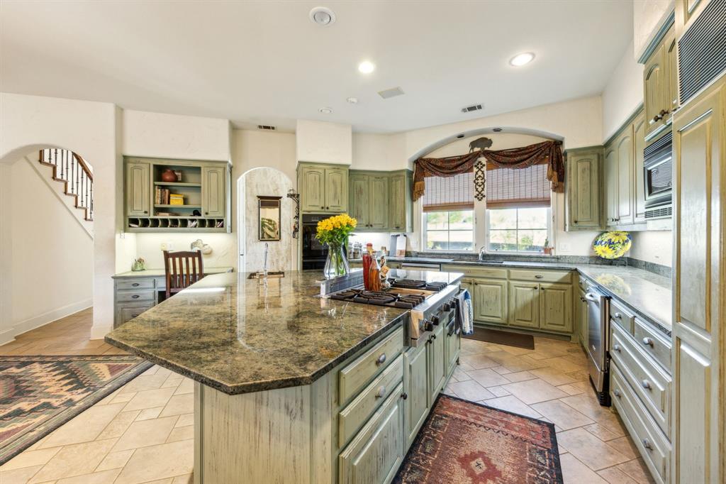 868 English Road Rockwall, TX 75032 - Photo 8 of 37 a kitchen with kitchen island granite countertop a sink a counter top space appliances and cabinets