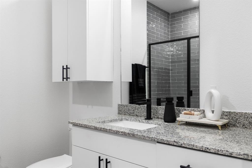 596 West 9th Street, Unit 339 Dallas, TX 75208 - Photo 19 of 22 Full bath with a textured wall, vanity, and a stall shower