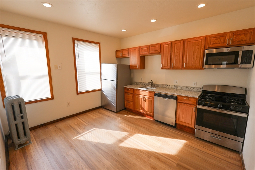 a kitchen with stainless steel appliances granite countertop a stove a sink and a microwave