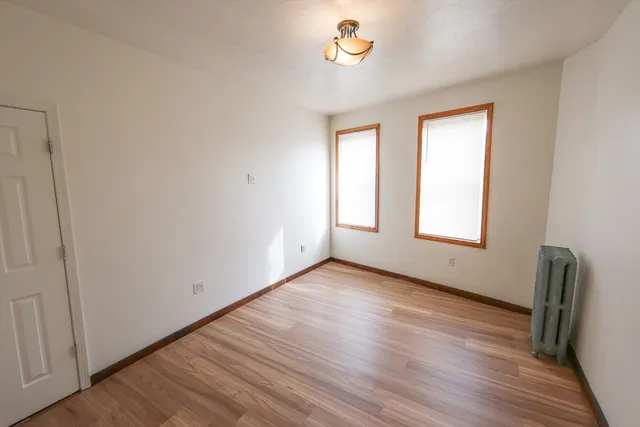 wooden floor in an empty room with a window
