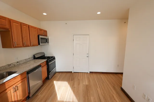 a kitchen with granite countertop wooden cabinets and a sink