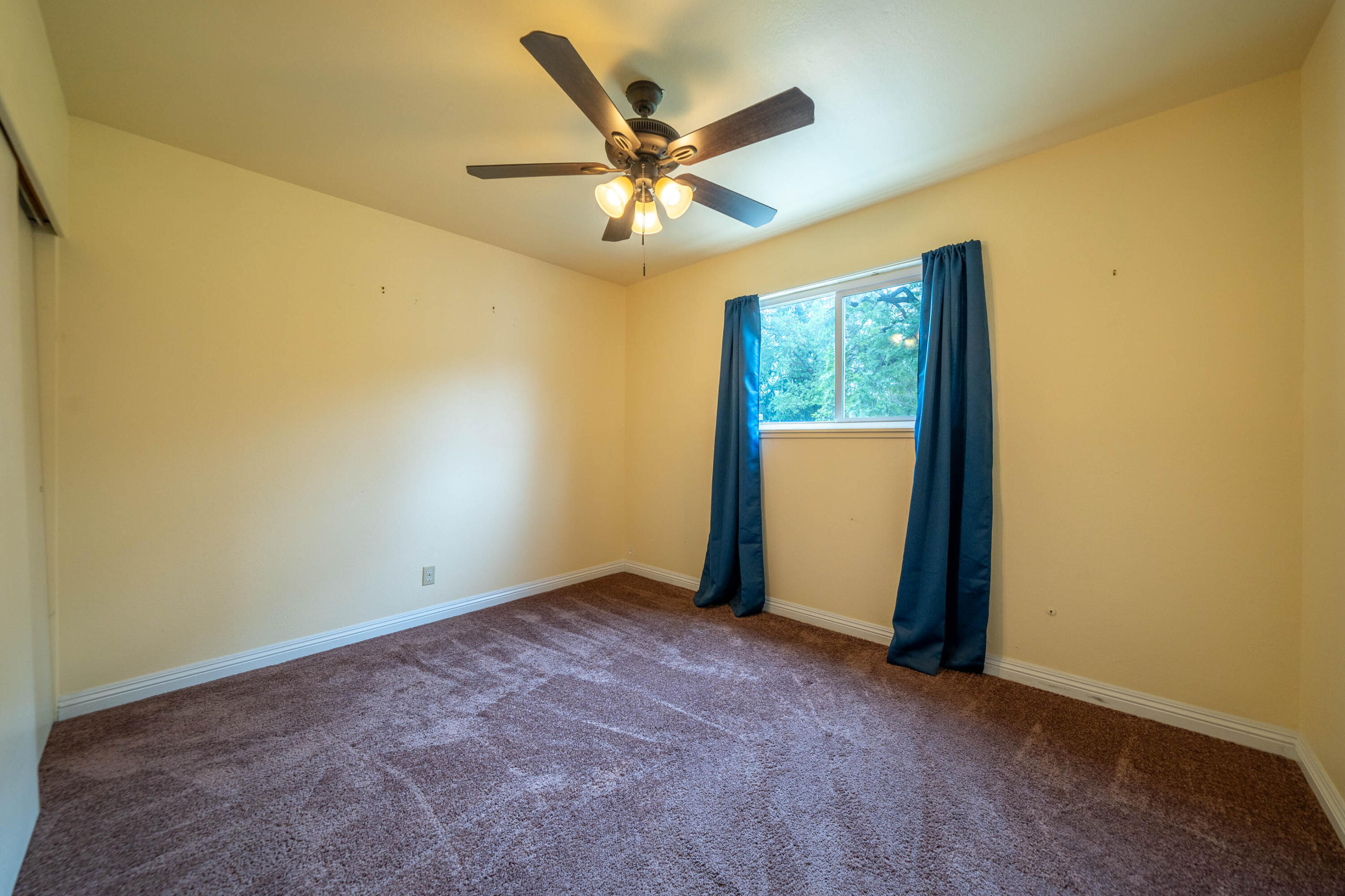 3055 Sharon Avenue Anderson, CA 96007 - Photo 21 of 52 an empty room with a ceiling fan and window