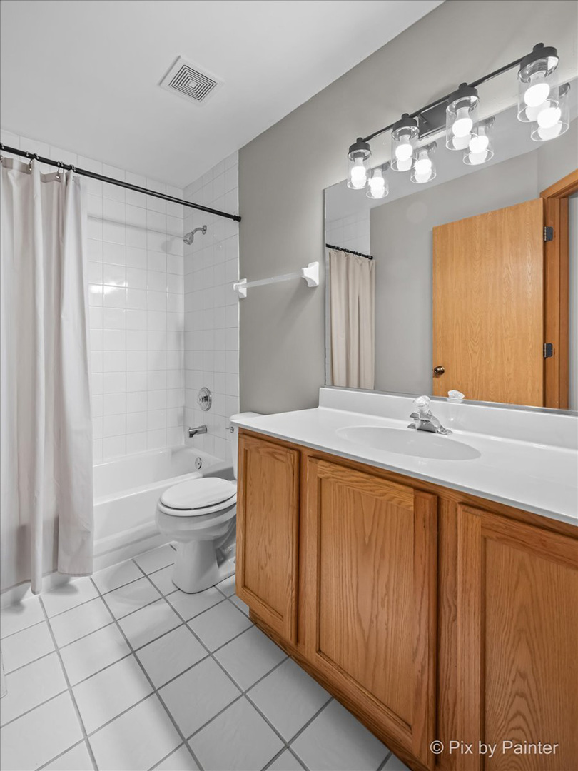2466 Amber Lane Elgin, IL 60123 - Photo 22 of 32 a bathroom with a toilet a sink and a large mirror
