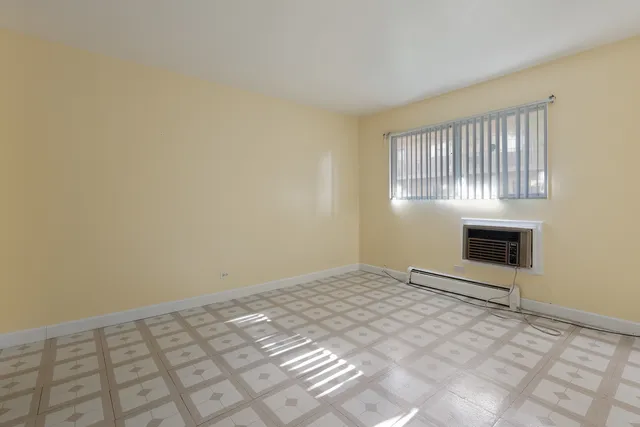 a view of an empty room with a window and fire place