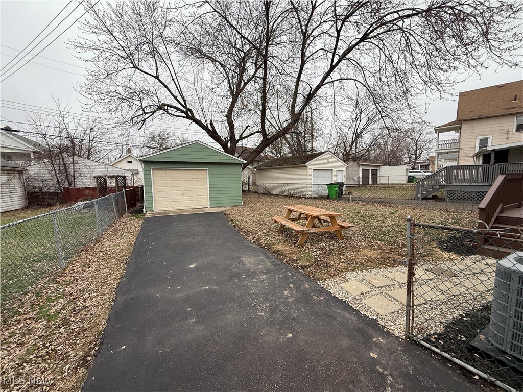 4658 Burleigh Road Cleveland, OH 44125 - Photo 23 of 24 View of yard featuring an outdoor structure, a garage, a deck, and driveway