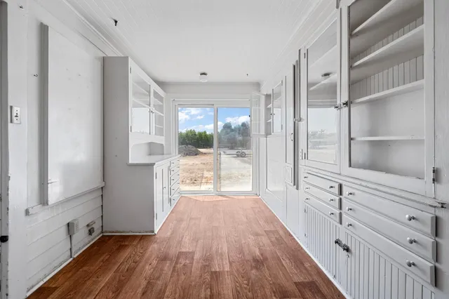 a view of a hallway with wooden floor and a window