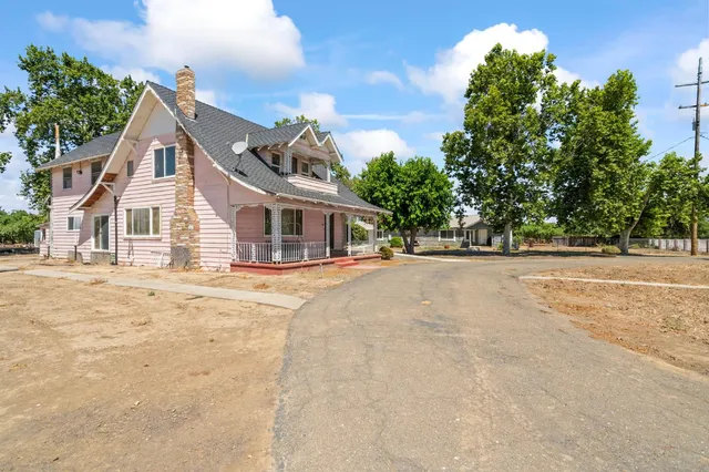 a view of house with yard and trees in the background