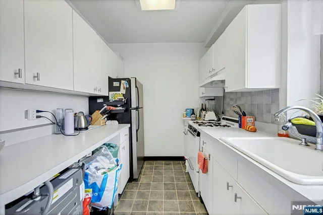 a kitchen with a sink a stove and cabinets