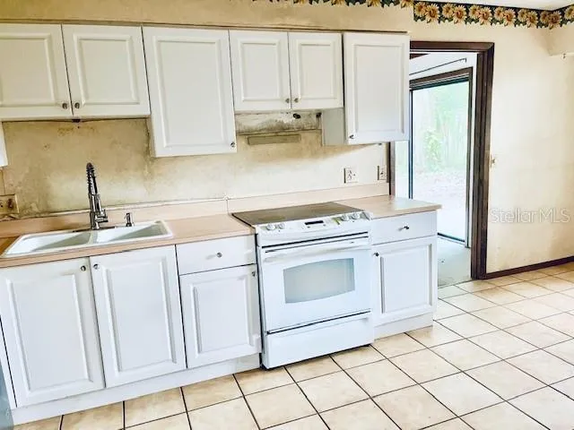 a kitchen with white cabinets and white appliances