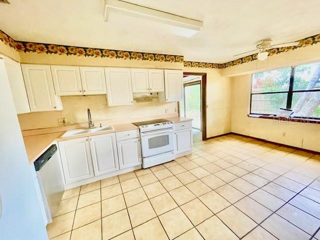7 Brookside Circle Ormond Beach, FL 32174 - Photo 6 of 16 a kitchen with a sink a stove top oven and white cabinets