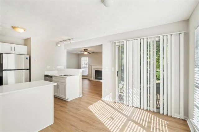 a open kitchen with white cabinets and a refrigerator