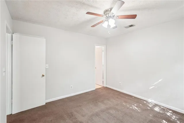 an empty room with a ceiling fan and a window