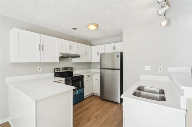 a kitchen with a refrigerator sink stove and cabinets