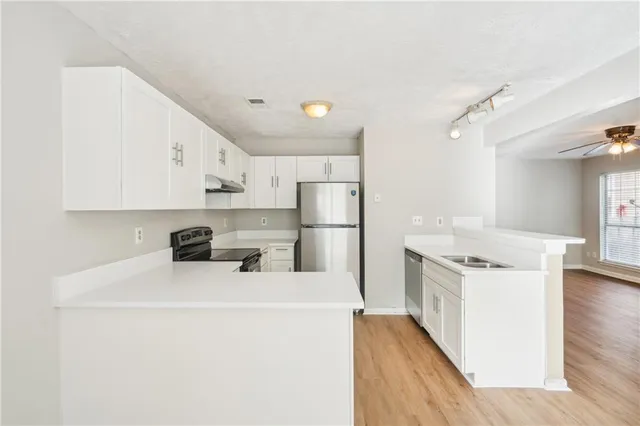 a kitchen with stainless steel appliances a refrigerator sink and cabinets