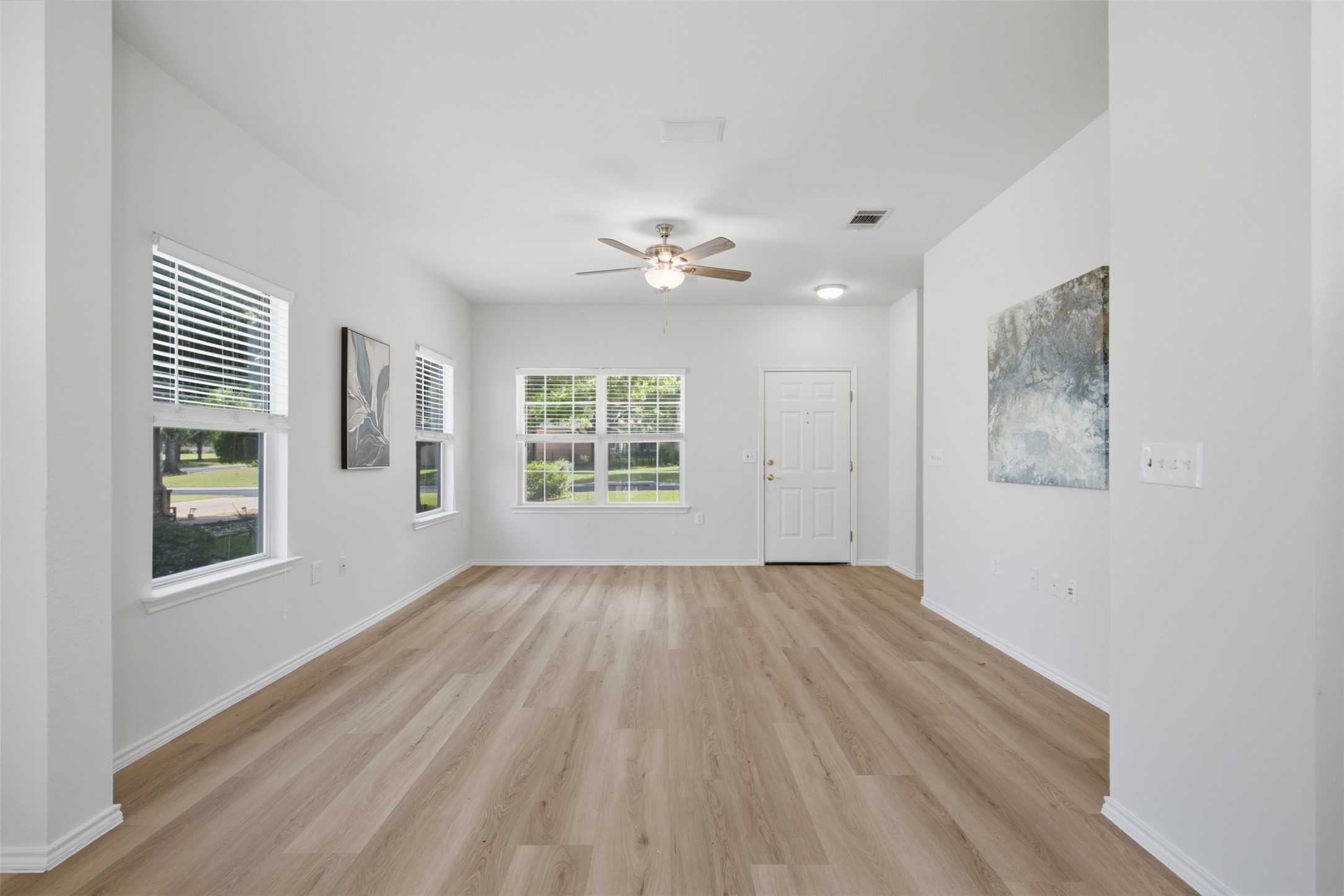 126 Whitewing Way Georgetown, TX 78633 - Photo 9 of 28 Wood-look flooring and multiple windows create a luminous, inviting living space.