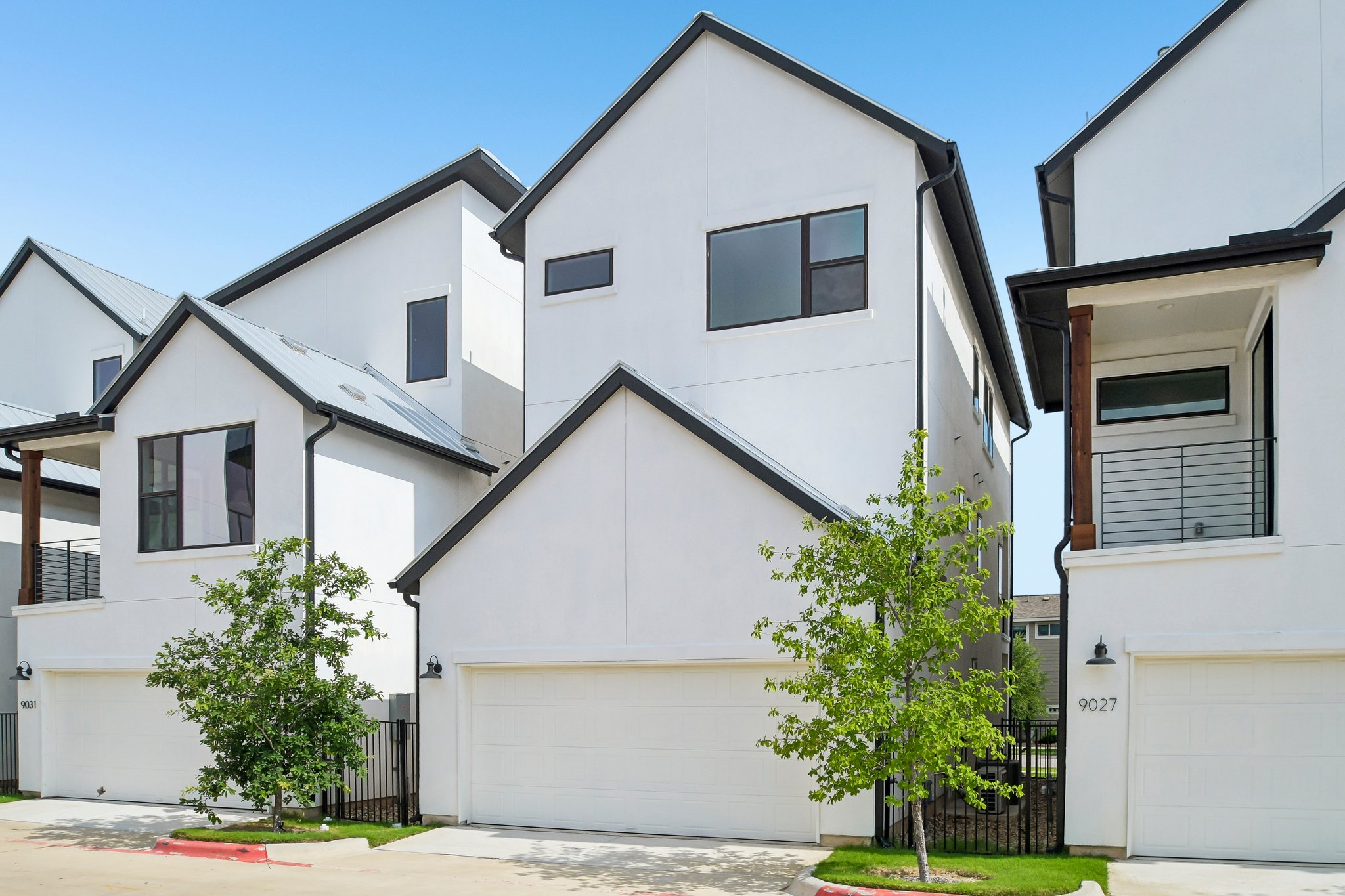 9029 Cattle Baron Path Austin, TX 78747 - Photo 35 of 37 Modern townhome exterior with crisp white stucco and striking black trim.