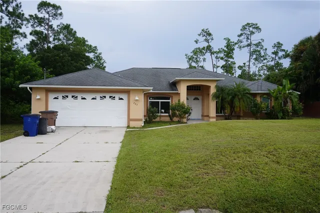 a front view of a house with a garden and trees