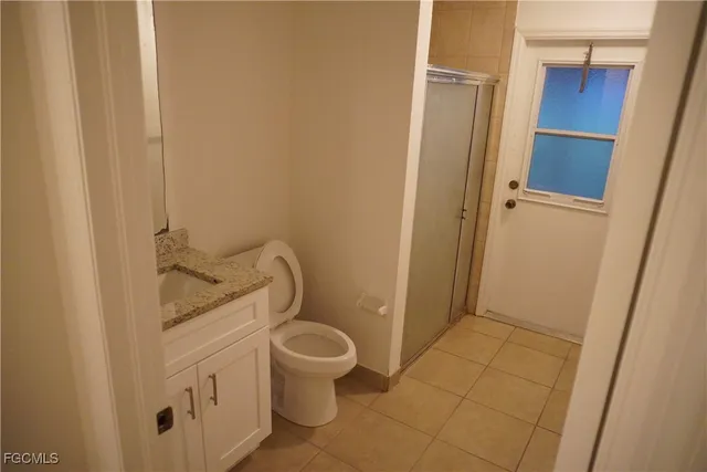 a bathroom with a granite countertop toilet and a sink